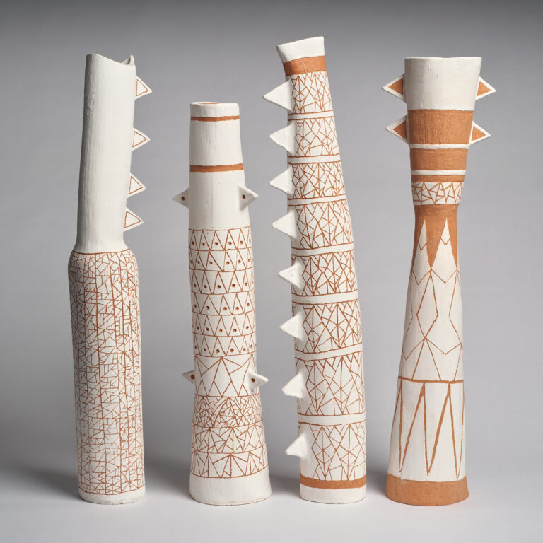 Curator assembled group of objects by Kaantju country artist Naomi Hobson. Contemporary, finely hand-built, sculptural pole structures. All similarly constructed from ochre-coloured clay with a matte white, slip underglaze throughout. Each object is uniquely decorated featuring slightly irregular, repeating patterns based on skin designs of circles and triangles that is incised around the body of the forms to reveal the ochre beneath. All objects feature similar, applied, triangle decorations protruding from the sides of the form. Kaantju. Aboriginal and Torres Straight Island. Australia